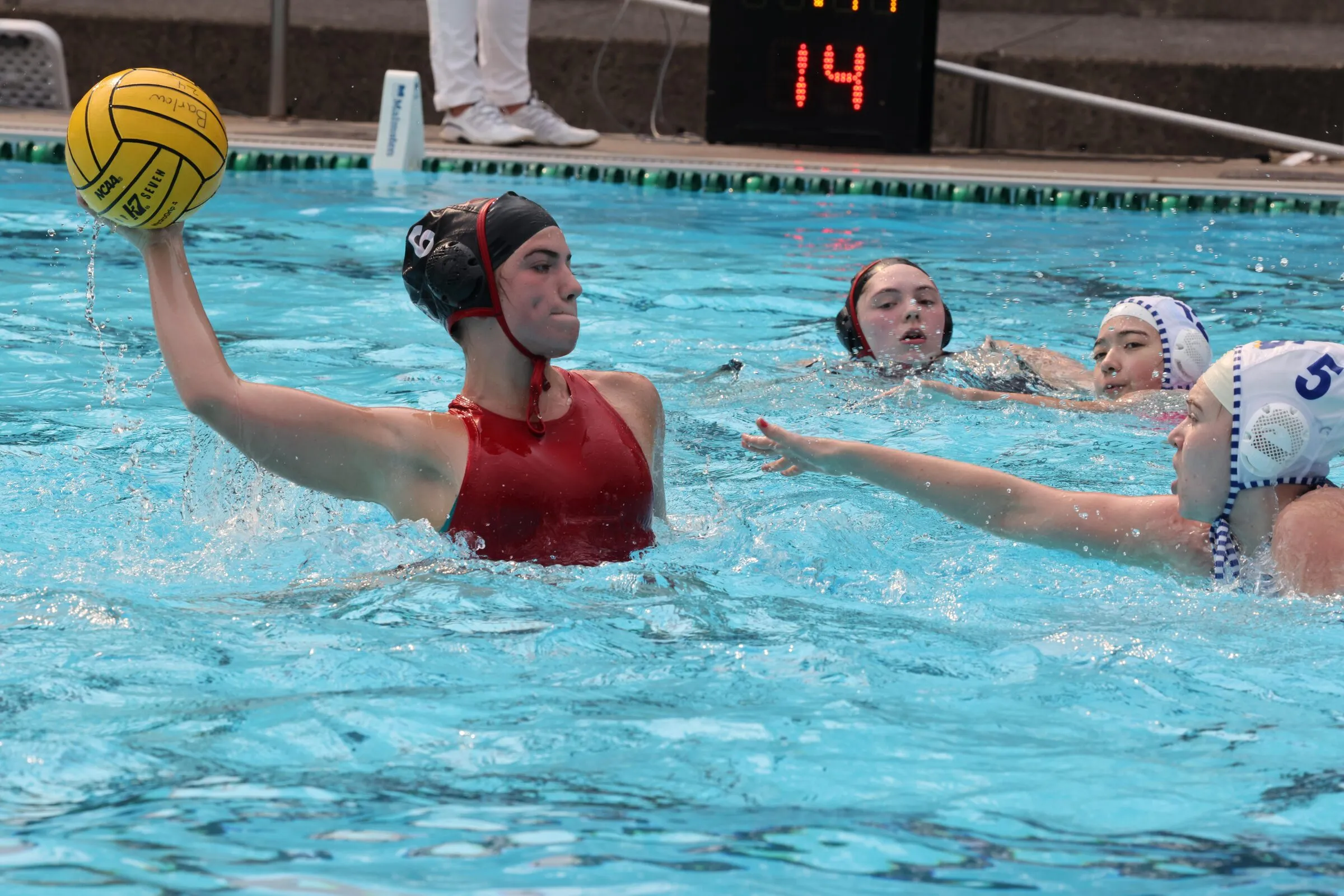 A Lincoln player in a red cap winds up to shoot